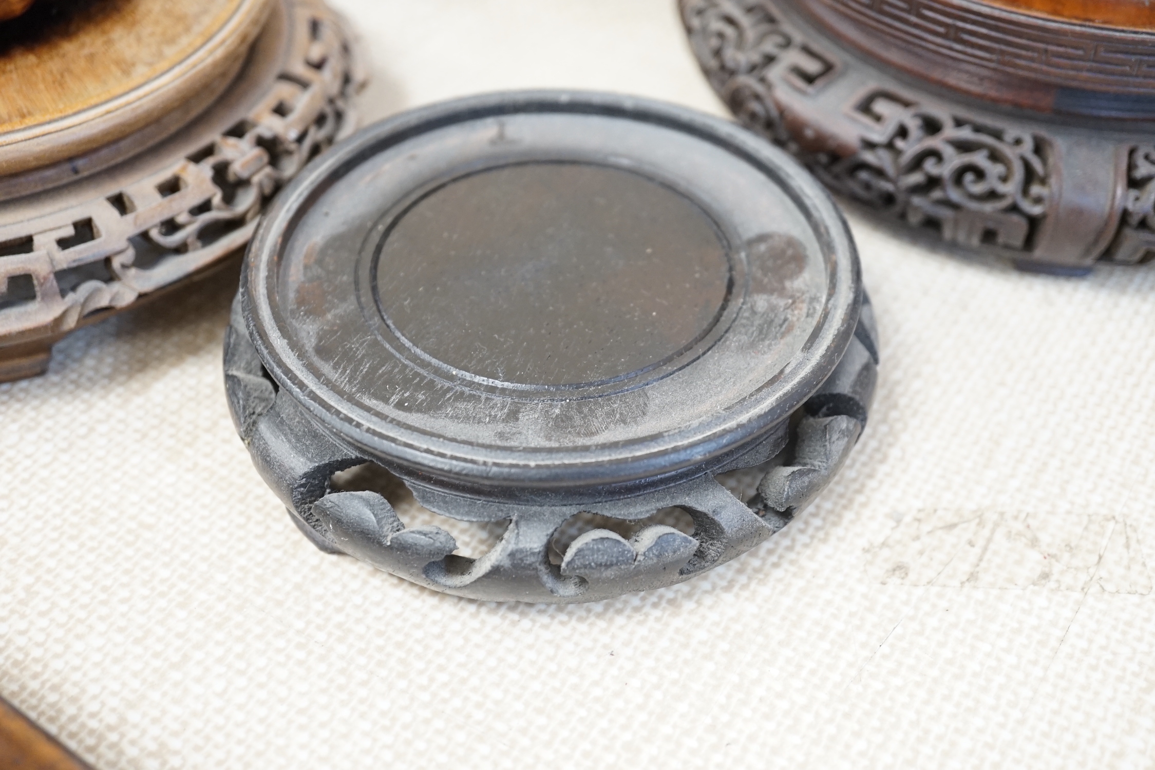 Seventeen Chinese carved wood stands of varying sizes, largest 30cm diameter
